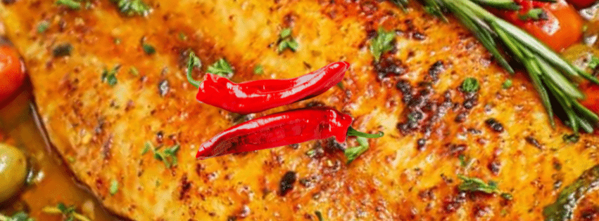 Filets de poisson blanc dorés au four avec tomates cerises, olives et piments rouges.